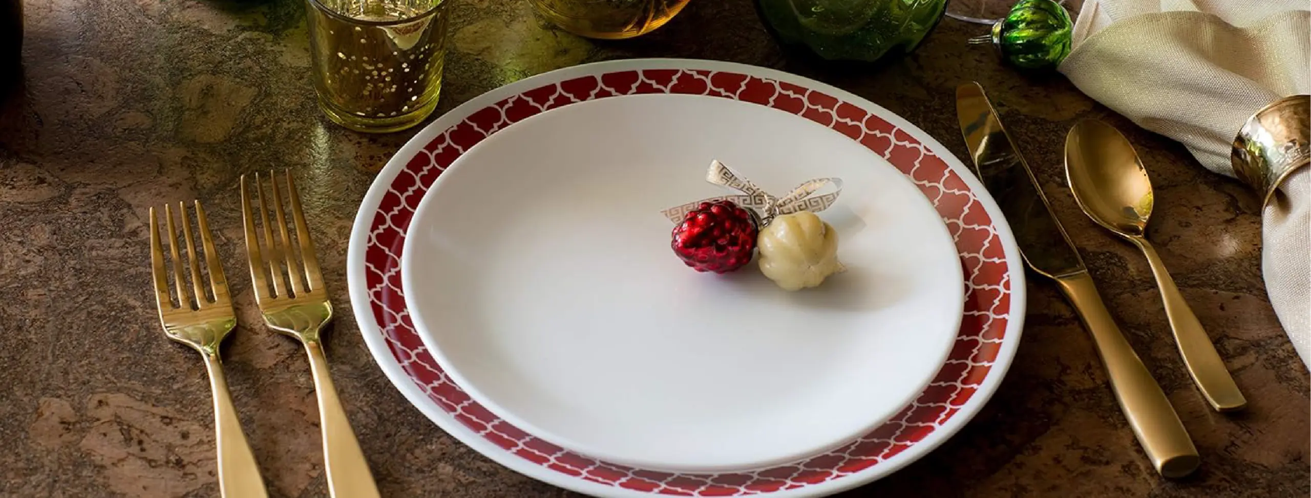 Corelle serviço Vitrelle Crimson TRellis em contecto com talheres dourados em mesa de madeira